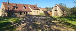 an old house with a large yard with a driveway at Les cabanes du veau in Daumeray