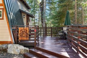 a wooden porch of a cabin with a table and an umbrella at Chief Peak in Fish Camp