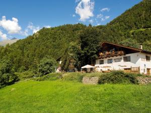 ein Haus auf einem Hügel vor einem Berg in der Unterkunft Gasthaus Gasteiger in Algund