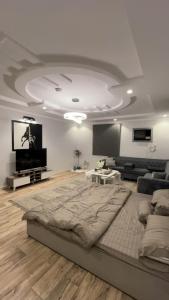 a living room with a large bed and a flat screen tv at لمسة فندقية راقية in Abū Marāgh