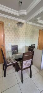 a dining room with a glass table and chairs at Apartamento próximo Aeroporto Cuiabá in Várzea Grande