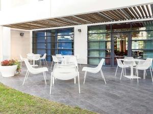 a group of white tables and chairs on a patio at Novotel Suites Nancy Centre in Nancy