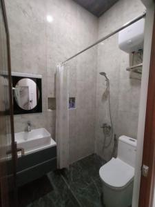 a bathroom with a toilet and a sink and a shower at Homestay Berlian T in Alastuwo +10 photos