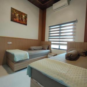 a bedroom with two beds and a window at Homestay Berlian T in Alastuwo