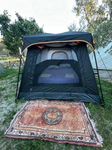 a tent sitting on the grass with a rug at Garden Lake Camping in Ksamil