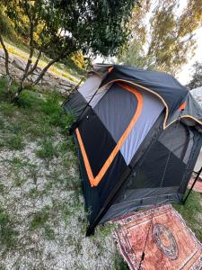 a black and orange tent sitting on the grass at Garden Lake Camping in Ksamil