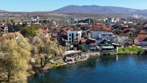 a town next to a river with houses and buildings at Una La Unica in Bihać