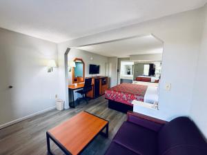 a hotel room with a bed and a couch and a table at Luxury Inn & Suites in Selma