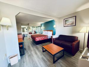 a hotel room with a bed and a couch at Luxury Inn & Suites in Selma