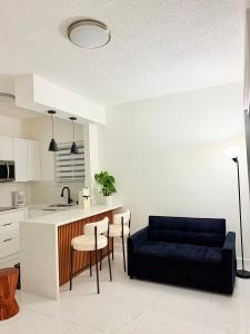 a living room with a blue couch in a kitchen at Beautiful House Near Marlins Stadium in Miami +12 photos