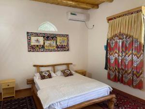 a bedroom with a bed and a window at Shirin Ethno House Yurt Camp in Shirin
