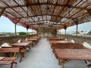 a row of wooden benches sitting inside of a building at Shirin Ethno House Yurt Camp in Shirin