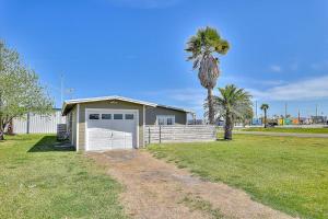 a house with a white garage and a palm tree at Wharf Cottage in Rockport