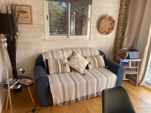 a blue couch with pillows in a living room at La Chambre Haute, spa et jardin extérieur à Nîmes in Nîmes