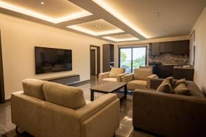 a living room with couches and a flat screen tv at Hillside hotel in Kenema