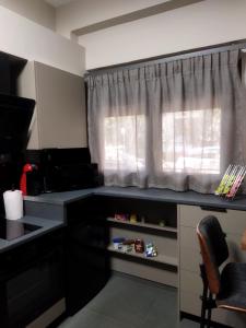 a kitchen with a black counter and a window at The swanky studio in Anatolí