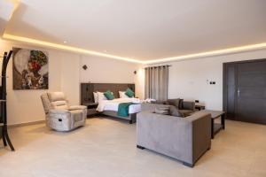 a hotel room with a bed and a couch and chair at Hillside hotel in Kenema +82 photos