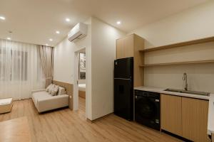 a kitchen with a black refrigerator and a living room at Residences A-25 in Hanoi +82 photos