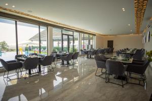 a dining room with tables and chairs and windows at Hillside hotel in Kenema