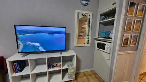 a flat screen tv sitting on top of a white cabinet at Studio in perfect location in Playa de las Americas