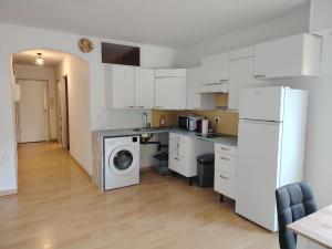a kitchen with white cabinets and a washer and dryer at Studio Hyeres sur le port in Hyères