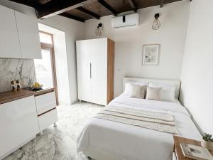 a white bedroom with a bed and a table at DaVilla Sanremo - Entire Villa, Sea View & Pool in Pampara +41 photos