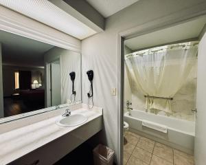 a bathroom with a sink and a large mirror at Luxury Inn & Suites in Selma +62 photos