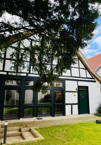 a white and black building with a green door at Eibenhaus in Bad Iburg