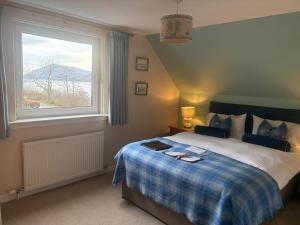 a bedroom with a large bed with a window at Torlinnhe in Fort William