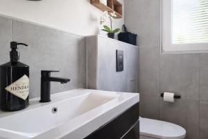 a bathroom with a sink and a bottle of wine at Ferienhaus Seeoase - 70qm - Kamin -Terrassen - Parkplatz - Badestelle fußläufig in Joachimsthal +24 photos