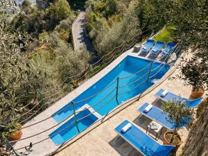 an overhead view of a pool with blue tables and chairs at DaVilla Sanremo - Entire Villa, Sea View & Pool in Pampara