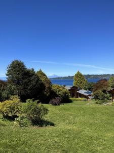 a field of grass with a lake in the background at Amadeus Hotel Boutique in Frutillar +39 photos
