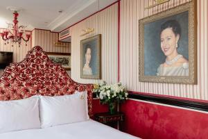 a bedroom with a bed and a portrait of a woman at Rubens At The Palace in London