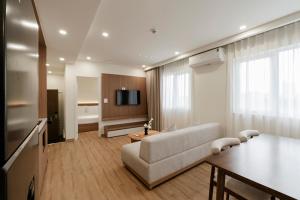 a living room with a couch and a table and a tv at Residences A-25 in Hanoi