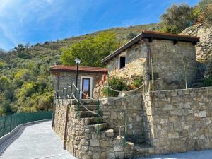 a stone house with a stone wall and stairs at DaVilla Sanremo - Entire Villa, Sea View & Pool in Pampara