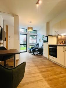 a kitchen and living room with a table and chairs at Eibenhaus in Bad Iburg