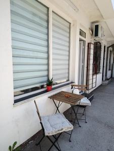 a porch with a table and two chairs and a window at Stan na dan Valjevo Centar in Valjevo