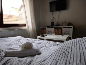 a white bed with a towel on top of it at Stan na dan Valjevo Centar in Valjevo