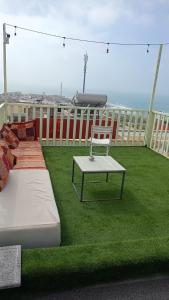 a balcony with two beds and a table on the grass at Atlantic Coast Imsouane in Imsouane +5 photos