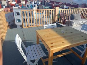 a wooden table and chairs on a balcony at Atlantic Coast Imsouane in Imsouane