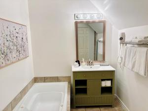 a bathroom with a tub and a sink and a mirror at Auberge Le Tricorne in North Hatley +53 photos