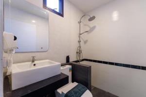 a bathroom with a sink and a toilet and a mirror at Lespalm Resort by Vacayandco in Ban Thalat Choeng Thale