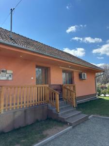 a home with a large wooden porch with stairs at Barackvirág-Vendégház in Érpatak