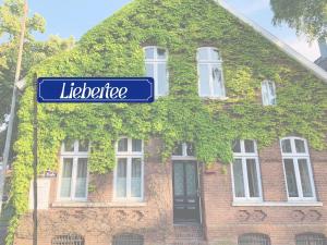 a blue street sign in front of a house at Altstadtrefugium "Backsteenhuus" und ,,Li ebertee" in Leer in Leer