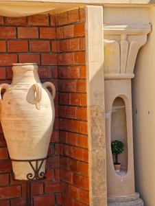 a brick wall with a vase and a plant in it at Dar Essaada - Exceptionel duplex de 270 M2, plage à 2 min à pieds in Mahdia
