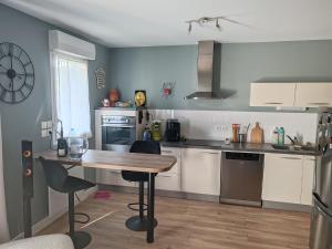a kitchen with a wooden table and a counter top at Chez FLO - Appartement 1 chambre privée in Angers +3 photos