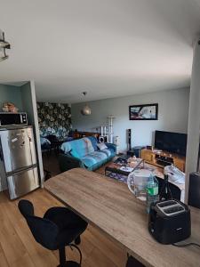 a living room with a table and a couch at Chez FLO - Appartement 1 chambre privée in Angers