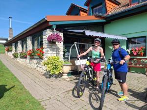 a man and a woman on bikes in front of a building at Penzion Ranch FAH in Spišské Podhradie
