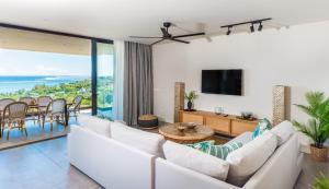 a living room with a white couch and a tv at Panoramic View Mauritius in Ruisseau Créole