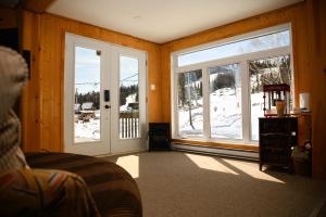 a room with two sliding glass doors with snow outside at Upper Floor - Mont-Video in Barraute